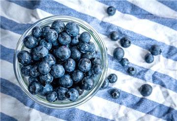 Beeren statt Chips oder Nüsschen: Heidelbeeren, auch Blaubeeren genannt, liegen auf einem Esstisch und werden gern gesnackt.