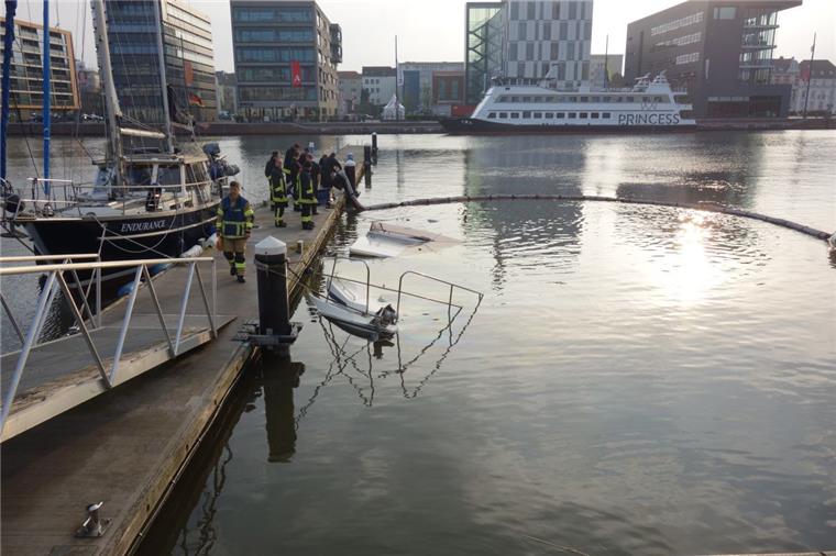 Begrenzt den Umweltschaden: Die Feuerwehr hat am Montagmorgen rund um die versunkene Motoryacht im neuen Hafen Ölsperren ausgelegt.
