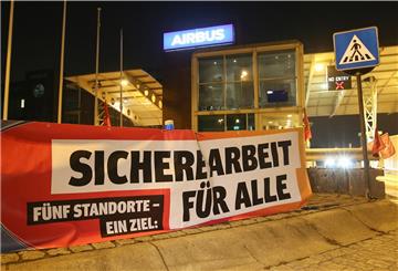 Ein Transparent mit der Aufschrift «Sichere Arbeit für Alle» hängt vor den Werkstoren des Flugzeugherstellers Airbus in Hamburg-Finkenwerder.