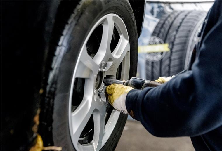 Wechsel zu Sommerreifen: Wann ist der richtige Zeitpunkt? Ein Werkstattmitarbeiter montiert einen Reifen am Auto.