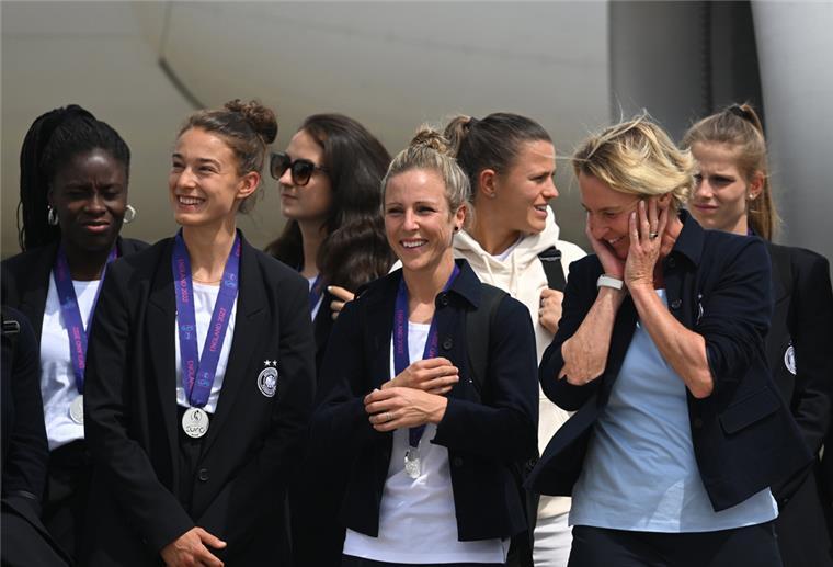 Frauen-Nationalmannschaft: Großer Jubel in Frankfurt Bei der Ankunft am Frankfurter Flughafen: Ein Teil der Mannschaft mit Bundestrainerin Martina Voss-Tecklenburg (von rechts vorne), Svenja Huth und Felicitas Rauch steht auf dem Flughafen nach dem Aussteigen vor dem Flugzeug.
