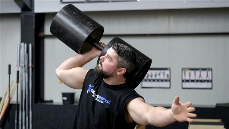 Er wirft Steine wie Obelix: Lucas Underwood stellt als Strongman Rekorde auf Ein Mann hebt eine große Hantel.