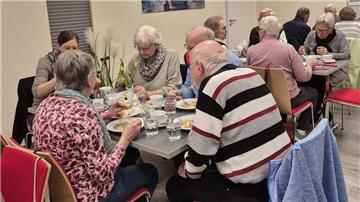 Ältere Menschen essen gemeinsam an Tischen. Bei der DRK-Aktion „Gemeinsam schmeckt es besser“ steht nicht nur der Eintopf, sondern vor allem das Miteinander am Mittagstisch im Mittelpunkt.