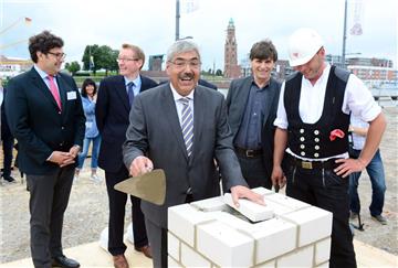 Bei der Grundsteinlegung für das Hotel „Liberty“ wird Oberbürgermeister Melf Grantz von Polier Thorsten Zierke assistiert. Dahinter von links:
Walter Brandner von der Raphael-Hotelgruppe sowie Stephan Meyerhoff und Architekt Andreas Heller von der Projektentwicklungsgesellschaft „Kaje der Auswanderung“, die als Bauherr fungiert und von Investoren aus Bremerhaven, Hamburg und Lübeck getragen wird.  Fotos (2) Scheer