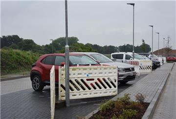 Das Foto zeigt den Parkplatz. Die Leuchten auf der Stellfläche werden durch Absperrgitter geschützt.  