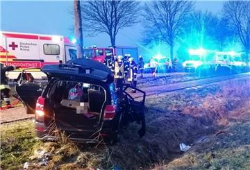 Kaputtes Auto an einem Baum, viel Blaulicht