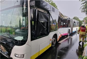 Der Zugführer der Feuerwehr Godshorn geht an einem stark beschädigten Linienbus an der Unfallstelle vorbei. 