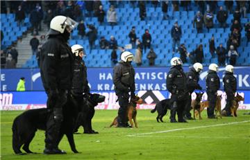 Bei einem Spiel zwischen dem Hamburger SV und  Hertha BSC stehen Polizisten mit Hunden nach dem Spiel auf dem Platz.