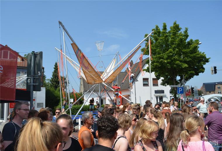 Menschen auf einer Straße mit Bungee-Trampolin im Hintergrund