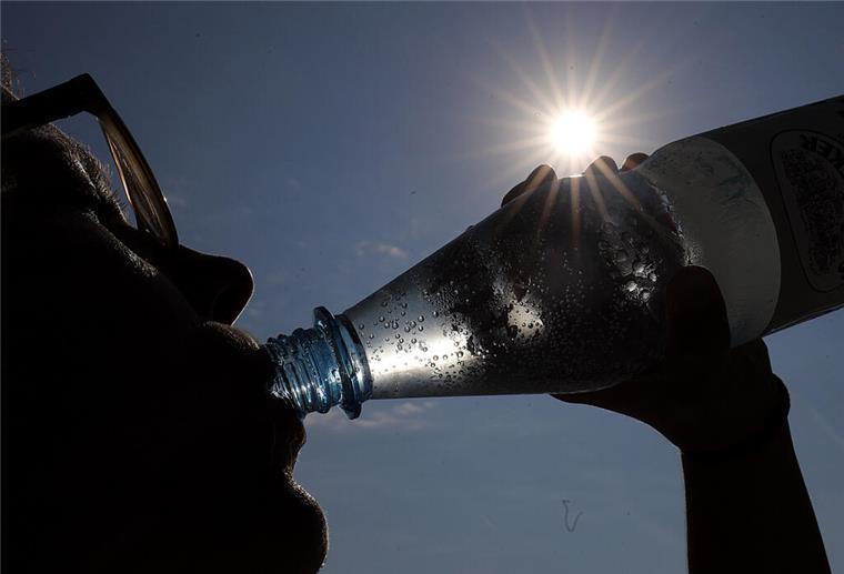 Eine Person trinkt aus einer Flasche Mineralwasser