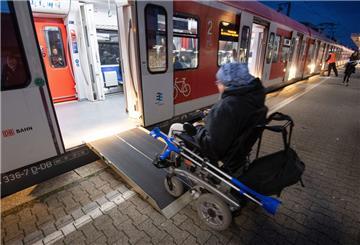 Rollstuhlfahrer fährt über elektrische Rampe in eine S-Bahn