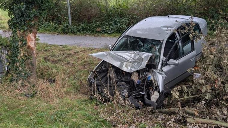 ein beschädigtes Auto steht nach einem Unfall teilweise in einem Graben