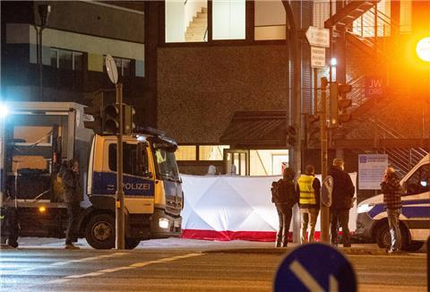 Polizisten stehen vor einem Gebäude der Zeugen Jehovas. 