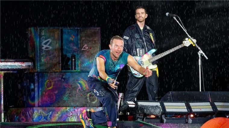 Bei starkem Regen beginnt Coldplay die Performance in Düsseldorf.