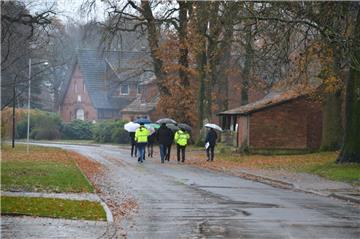 Bei Wind und Regen machten sich Vertreter des Gemeinderates und der Verwaltung in Begleitung der drei Bauleiter gut beschirmt ein Bild von den abgeschlossenen Bauarbeiten in der Mulmshorner Straße. 