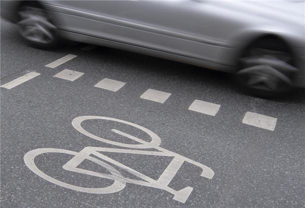 09.04.2019, Hessen, Frankfurt/Main: Ein Auto fährt an einer Kreuzung in der Innenstadt an einem Radweg vorbei. In Hessen ist Fahrradfahren in Frankfurt am gefährlichsten. Im vergangenen Jahr ereigneten sich in Hessens größter Kommune die meisten Radunfälle, wie aus dem Jahresbericht des Statistischen Landesamts hervorgeht. Foto: Boris Roessler/dpa +++ dpa-Bildfunk +++