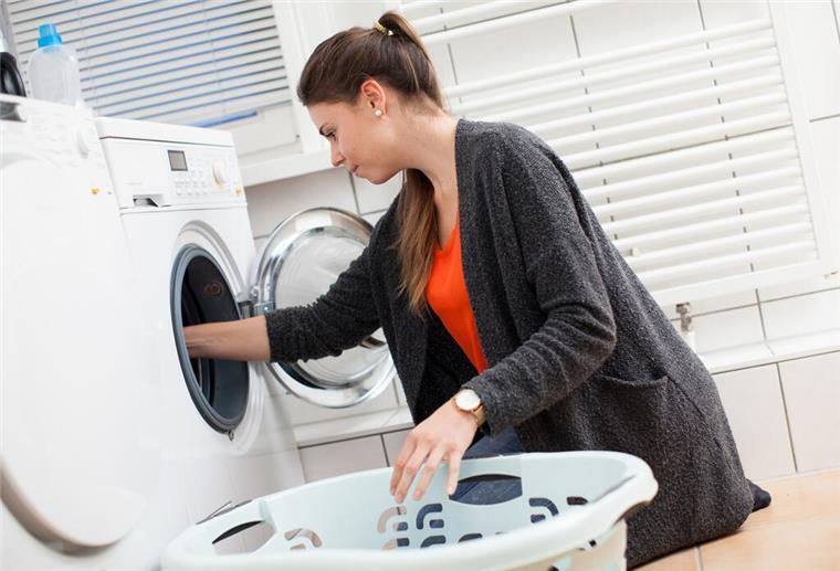 Verbraucherschützer: Dahin verschwinden Socken in der Waschmaschine Frau an Waschmaschine