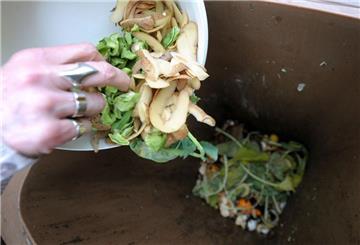 Eine Persin füllt eine Biotonne. Biomüll sollte ohne Plastiktüte in die Biotonne kommen - selbst wenn es sich um kompost
ierbare Tüten handelt.