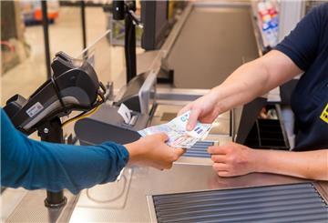 In einem Supermarkt hebt eine Kundin beim Bezahlen auch gleich Bargeld ab.