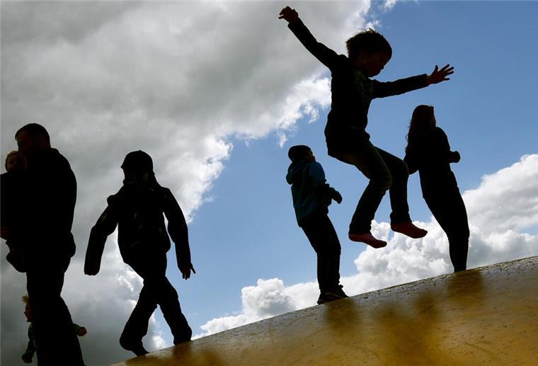 Neun Hüpfburgen bei Fest im Spielpark Leherheide ARCHIV - 17.05.2015, Brandenburg, Elstal: Kinder springen auf einer Hüpfburg und heben sich dabei als Schatten vom Himmel ab. (zu dpa "Milliarden-Paket für Familien: Entlastung ab 2019" am 27.06.2018) Foto: Ralf Hirschberger/dpa-Zentralbild/dpa +++ dpa-Bildfunk +++