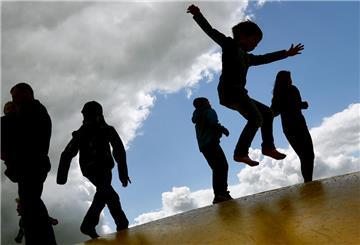 ARCHIV - 17.05.2015, Brandenburg, Elstal: Kinder springen auf einer Hüpfburg und heben sich dabei als Schatten vom Himmel ab. (zu dpa "Milliarden-Paket für Familien: Entlastung ab 2019" am 27.06.2018) Foto: Ralf Hirschberger/dpa-Zentralbild/dpa +++ dpa-Bildfunk +++