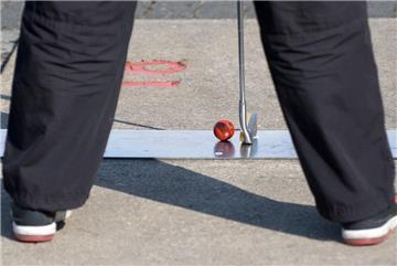 Ein Kind spielt auf dem Minigolf-Platz