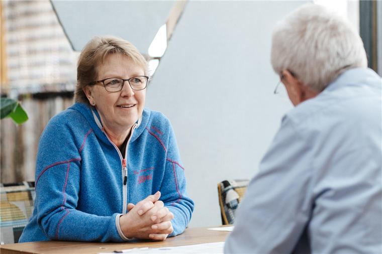 Eine Frau und ein Mann sitzen sich an einem Tisch zu einem Beratungsgespräch gegenüber
