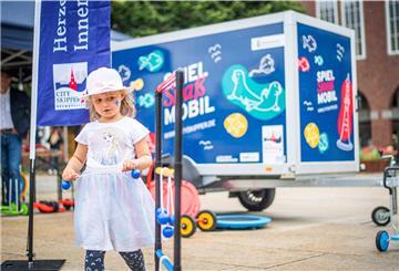 Beim Start des Spiel- und Spaßmobils für Kinder in der Bremerhavener Fußängerzone probiert Emma (5) die mobilen Spielsachen aus.