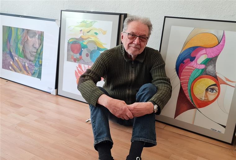 Ein Mann sitzt vor Kunstwerken