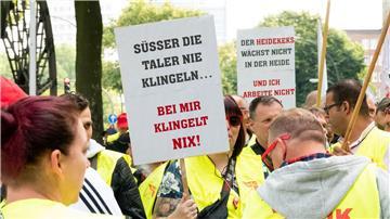 Beschäftigte der Süßwarenindustrie stehen während einer Kundgebung zusammen.