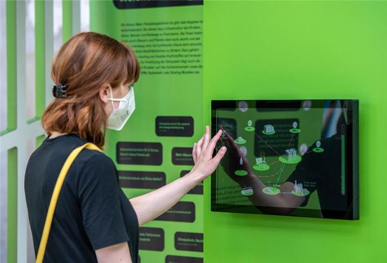 Ausstellung in Klimahaus Bremerhaven wirbt für Energiewende Eine Frau steht an einem Automaten.