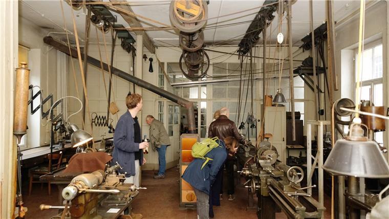 Besucherinnen und Besucher schauen sich in einer alten Werkstatt aus dem Jahr 1936 um. 