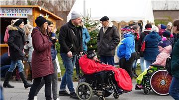 Besucherinnen und Besucher sind auf dem inklusiven Weihnachtsmarkt unterwegs.
