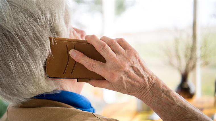 Eine Seniorin telefoniert mit einem Smartphone