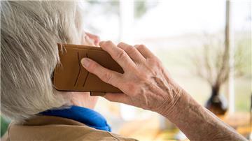 Eine Seniorin telefoniert mit einem Smartphone