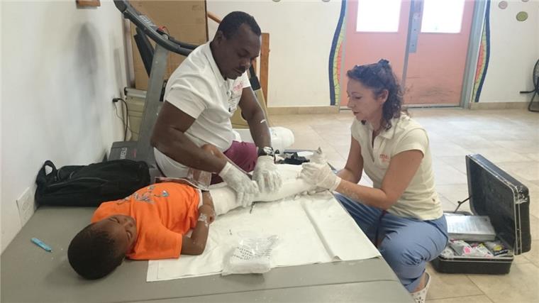 Bettina Schüller nimmt gemeinsam mit einem Kollegen bei einem kleinen Jungen in Haiti einen Gipsabdruck