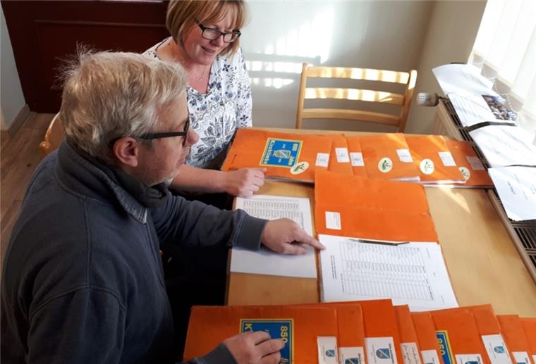 Bevor die Mappen verteilt werden können, müssen Frank Tibke und seine Frau Melanie per Hand die Zettel der örtlichen Vereine und Institutionen einsortieren.