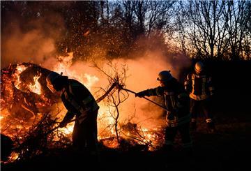 Feuerwehrkräfte schichten ein Osterfeuer auf.