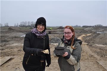 Bezirksarchäologin Dr. Jana Fries (links) und Grabungsleiterin Sarah Enders zeigen zwei Fundstücke, die in der Wurt entdeckt worden sind. Die Keramikscherben stammen aus dem späten Mittelalter. Die Wurt liegt in dem Bereich der Deponieerweiterungsfläche
in Nordenham-Galing, der ab Herbst befüllt werden soll.