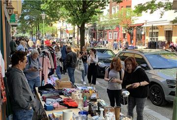 Besucherinnen und Besucher stöbern an mehreren Flohmarktständen in der Straße "Alte Bürger"