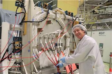 Startklar: Ein Bündel weißer Kabel zeigt Programmleiter Andreas Schütte, vor der Plattform „Bartolomeo“. Die Kabel werden über das tonnenförmige ISS-Modul „Columbus“ gelegt und sorgen für Strom und Datenfluss.