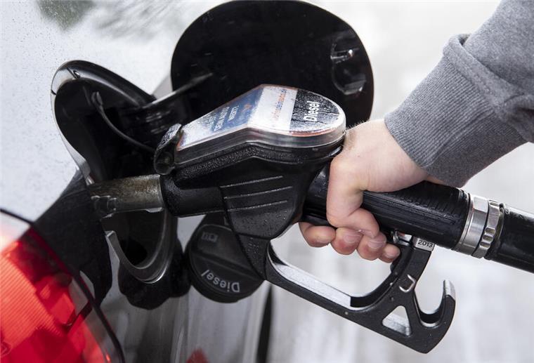 Eine Person hält einen Zapfhahn und betankt damit ihr Auto. Die beste Zeit zum Tanken hat sich geändert. 