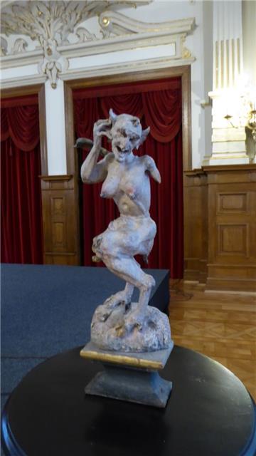 Bis 1924 war der "Geflügelte Teufel" Teil des Altars in der Tossenser Kirche. Da schon ein Arm und ein Flügel abgefallen sind, musste er im Landesmuseum in Oldenburg eingelagert werden.