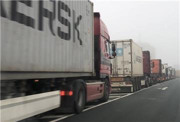 Container-Lkw stauen sich im Nebel in Richtung Überseehafen und Container-Terminal.