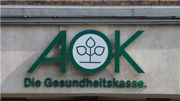 Blick auf das Logo der Krankenkasse AOK an einem Gebäude.