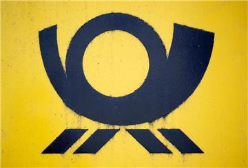 Blick auf einen Briefkasten der Deutschen Post, auf dem das Posthorn-Logo zu sehen ist.