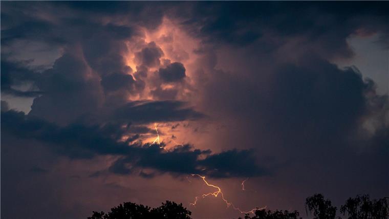 Hitze und Unwetter mit Starkregen erwartet Blitze entladen sich während eines Gewitters.
