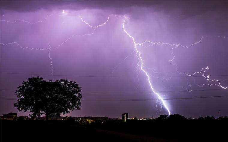 Blitze zucken während eines Gewitters am abendlichen Himmel.