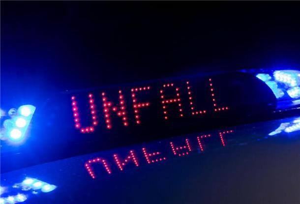 ILLUSTRATION - Das Blaulicht auf einem Fahrzeug der Polizei leuchtet in der Dunkelheit, während auf dem Display der Hinweis «Unfall» zu lesen ist. (zu dpa: «Auto prallt gegen Baum - Fahrerin schwer verletzt»)