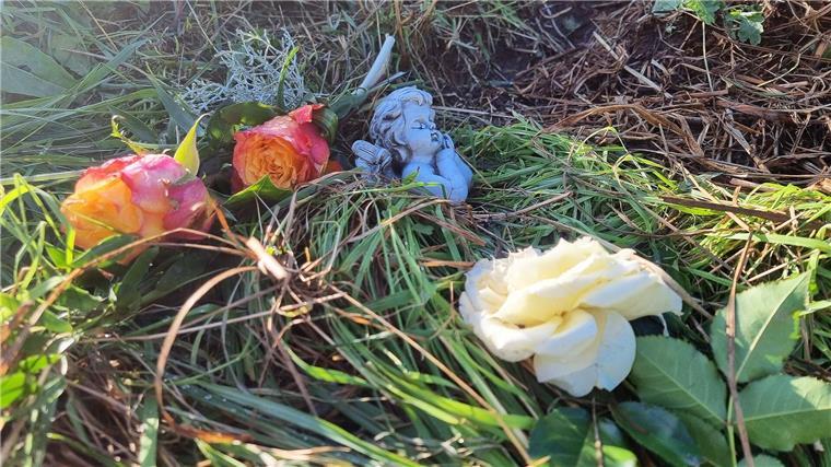Blumen und eine Engelsfigur liegen am Tatort im niedersächsischen Landkreis Diepholz.